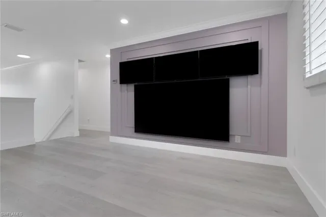 a view of an empty room with a fireplace and a window