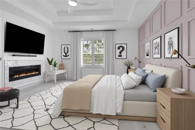 a bedroom with a bed a flat screen tv and a fireplace