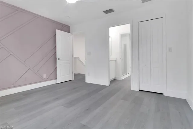an empty room with wooden floor and closet