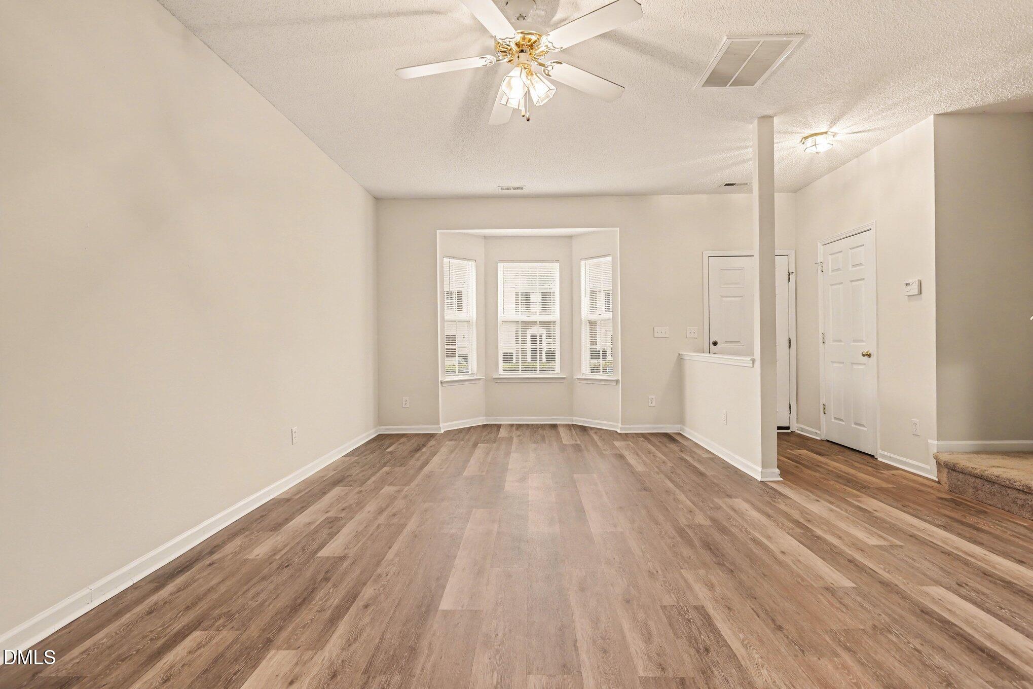 10947 Pendragon Place Raleigh, NC 27614 - Photo 3 of 21 wooden floor in an empty room with a window