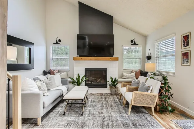 a living room with furniture a flat screen tv and a fireplace