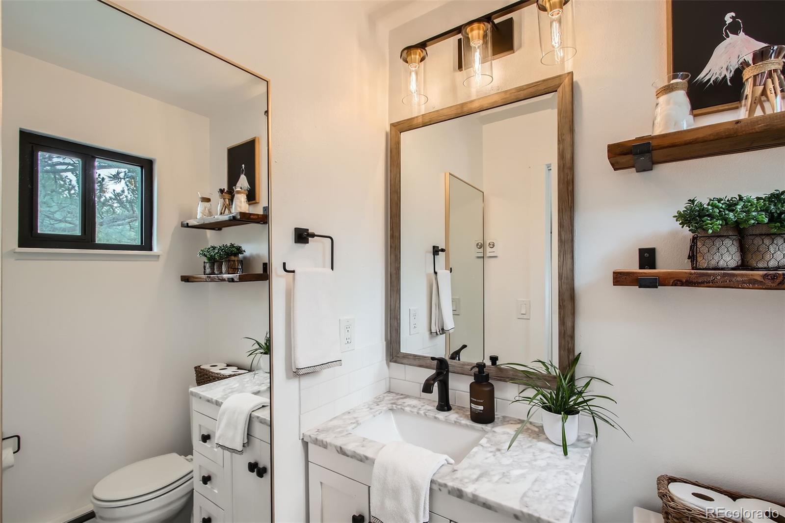 16626 Ouray Road West Pine, CO 80470 - Photo 17 of 50 a bathroom with a granite countertop sink a toilet and a mirror