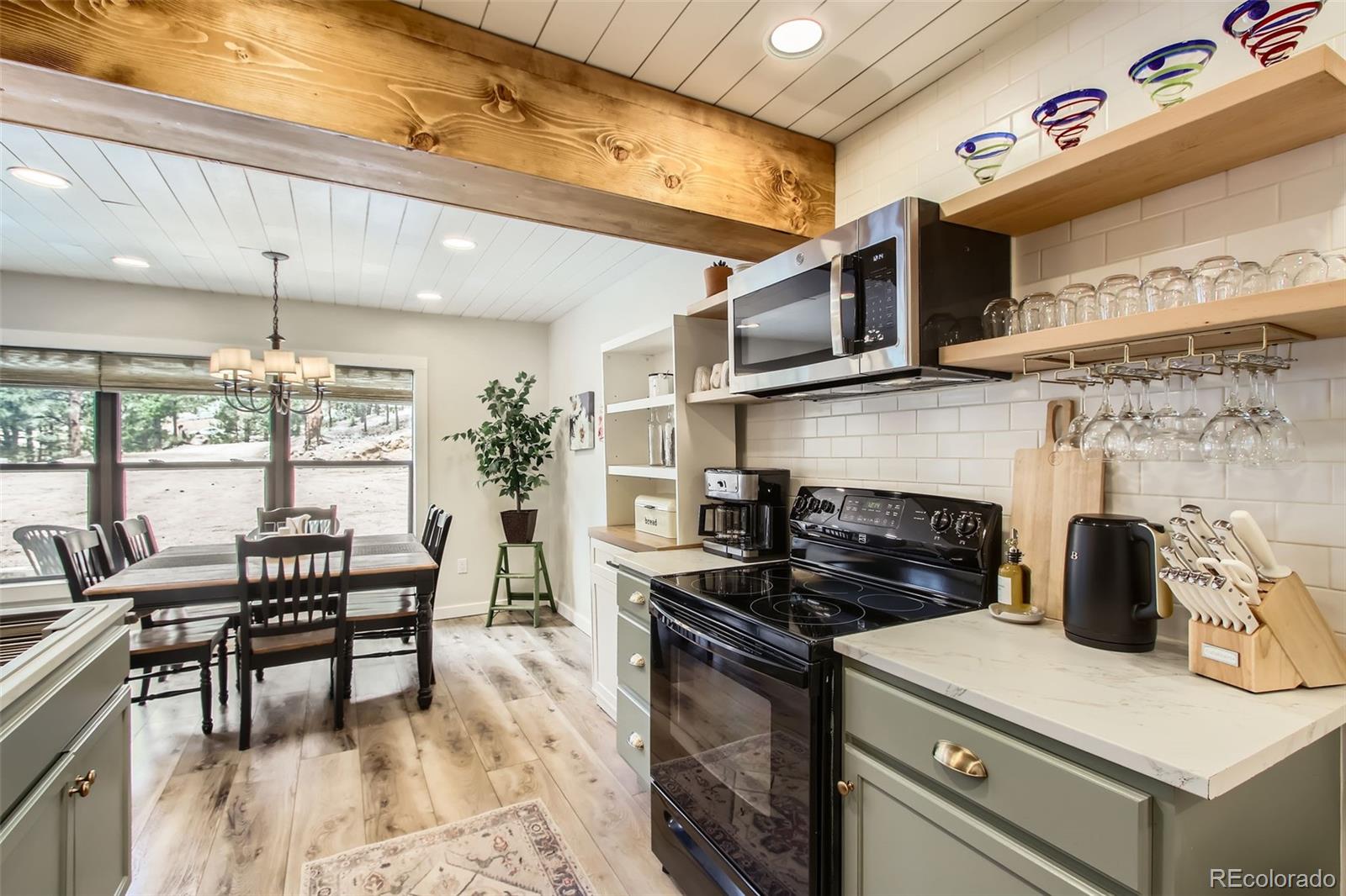 16626 Ouray Road West Pine, CO 80470 - Photo 30 of 50 a kitchen with stainless steel appliances granite countertop a stove and a view of living room