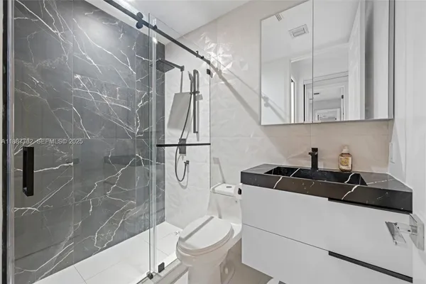 a bathroom with a sink a toilet and shower