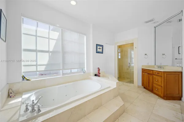 a spacious bathroom with a tub sink and mirror