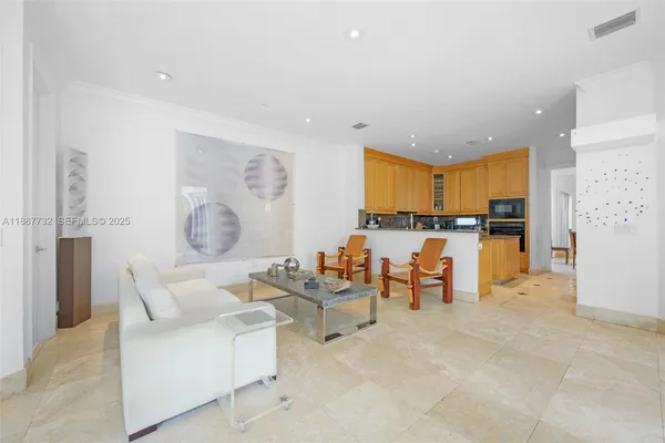 a living room with furniture and kitchen view