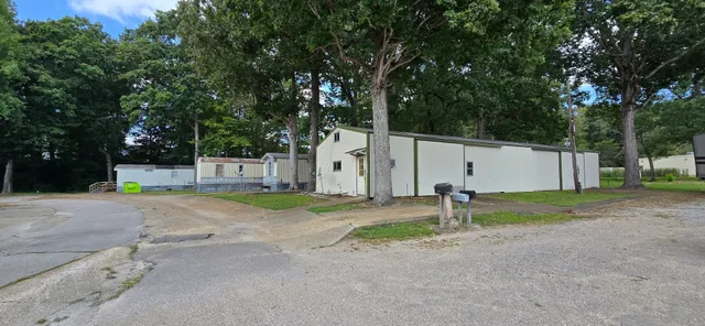 a backyard of a house with a trees and sign