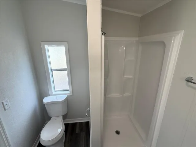 a bathroom with a toilet and a shower