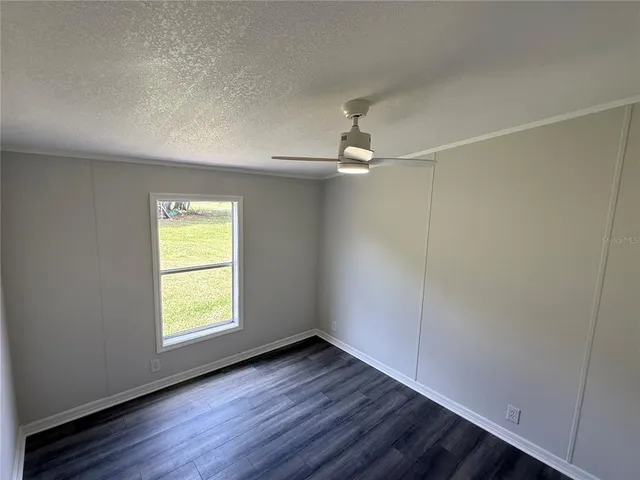 an empty room with a window and wooden floor