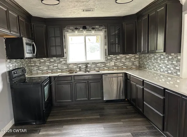 a kitchen with stainless steel appliances granite countertop a sink stove and cabinets