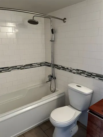 a white toilet sitting next to a bath tub