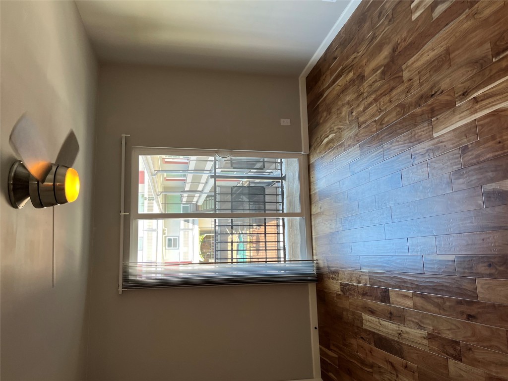 3110 Red River Street, Unit 216 Austin, TX 78705 - Photo 2 of 22 a view of an empty room with wooden floor and a window