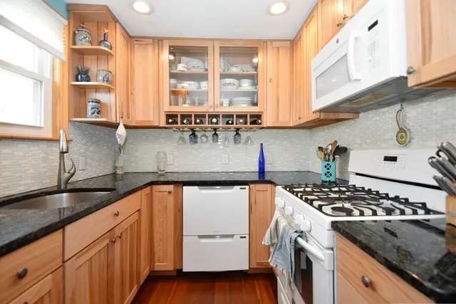 a kitchen with stainless steel appliances granite countertop a sink stove and cabinets