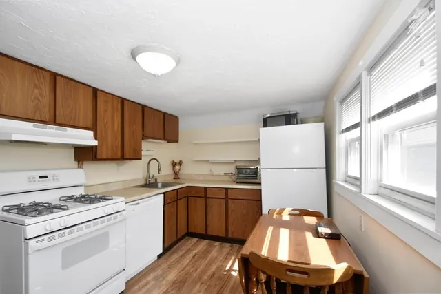 a kitchen with a sink a stove a refrigerator and cabinets