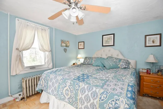 a bedroom with a large bed and a chandelier