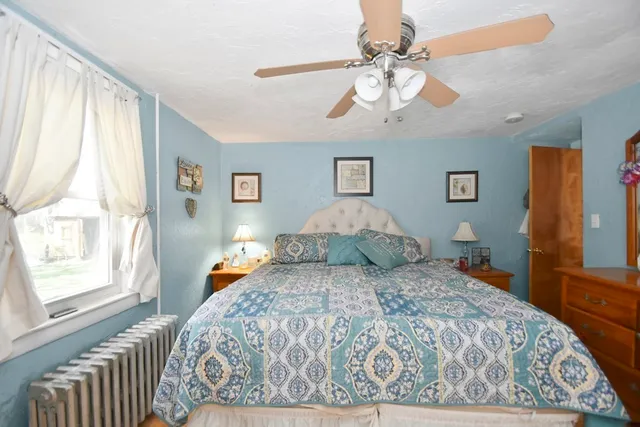a bedroom with a large bed and a chandelier