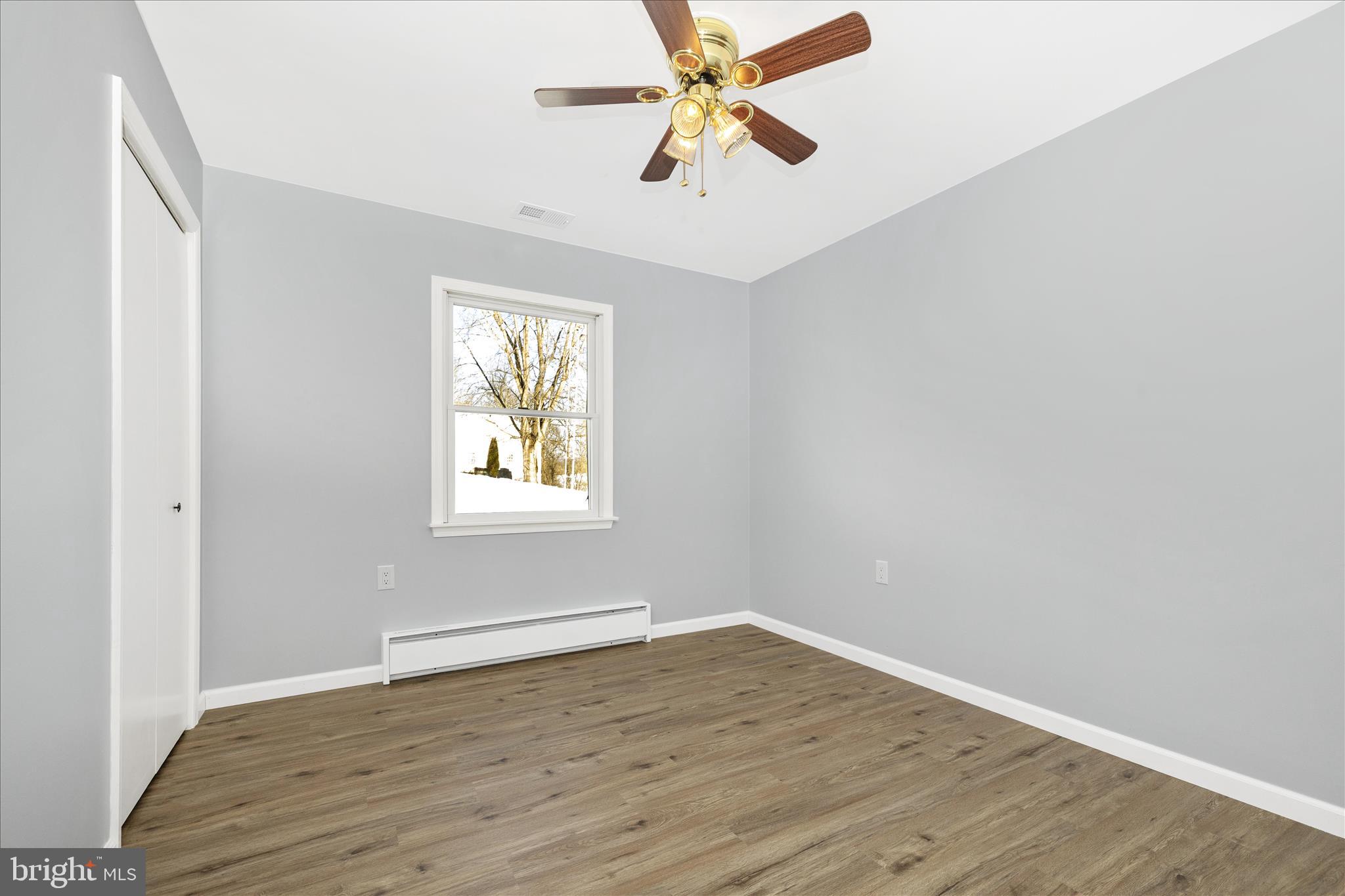 2640 Jefferson Pike Jefferson, MD 21755 - Photo 22 of 63 an empty room with wooden floor ceiling fan and windows