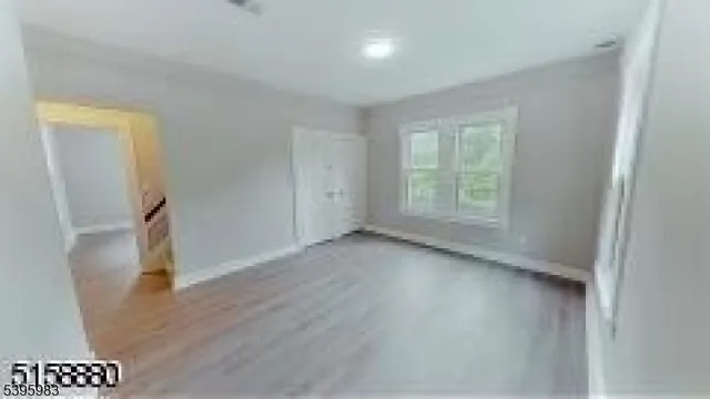 an empty room with wooden floor and a window