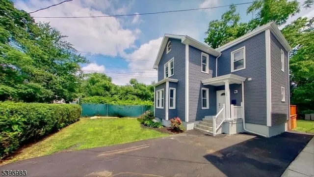 a front view of a house with a yard and potted plants