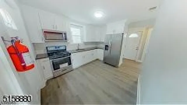 a kitchen with stainless steel appliances granite countertop a refrigerator a stove a sink and a microwave