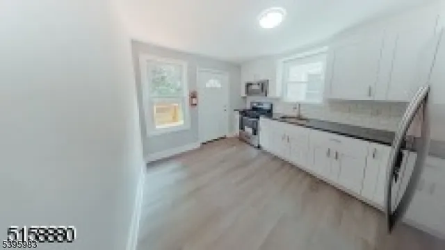 a kitchen with granite countertop white cabinets and white appliances