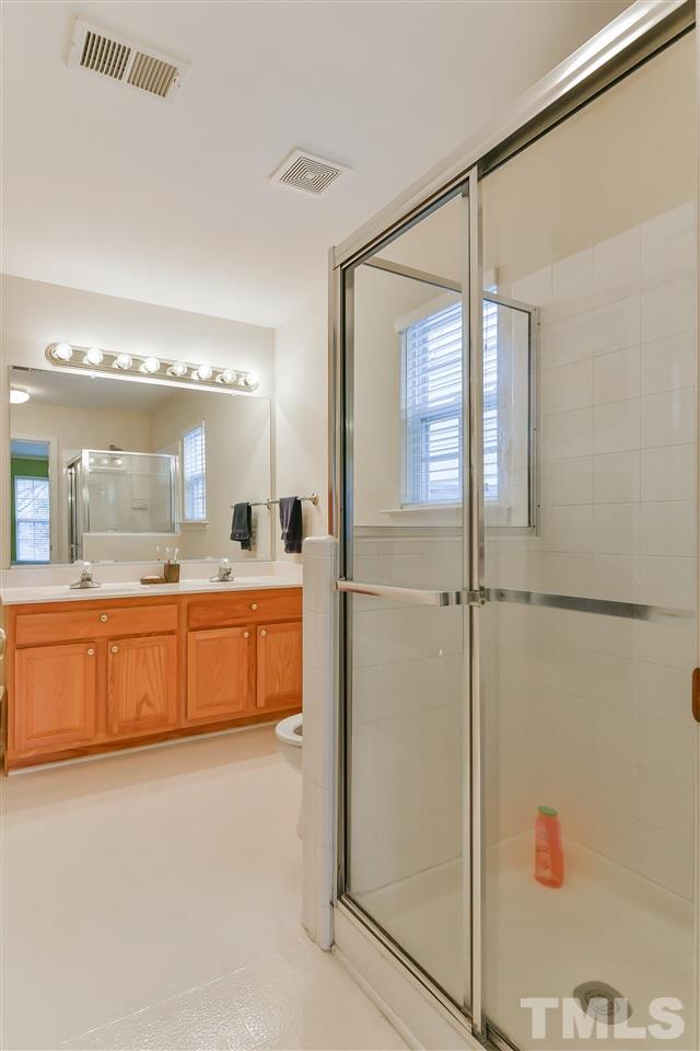 5312 Eolian Court Raleigh, NC 27607 - Photo 8 of 9 a large bathroom with a large mirror vanity and shower
