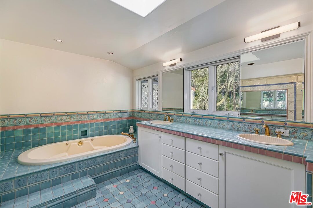 1130 Tower Road Beverly Hills, CA 90210 - Photo 17 of 30 a bathroom with a granite countertop tub a double vanity sink and mirror