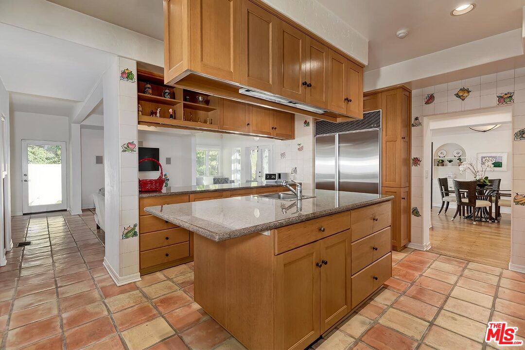 1130 Tower Road Beverly Hills, CA 90210 - Photo 9 of 30 a kitchen with stainless steel appliances granite countertop a sink and a refrigerator