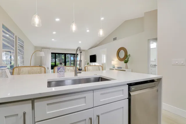 a room with stainless steel appliances kitchen island granite countertop furniture and a refrigerator
