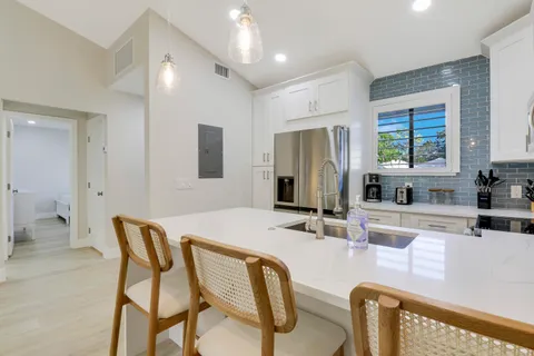 a kitchen with stainless steel appliances granite countertop a stove a sink and a refrigerator