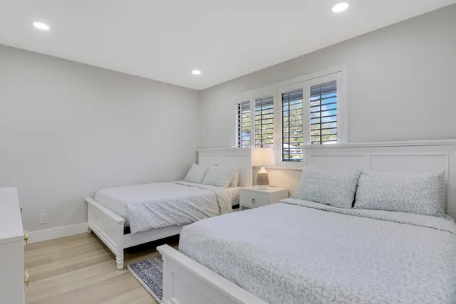 a bedroom with two beds and a window