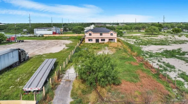 an aerial view of a house with a yard and greenery