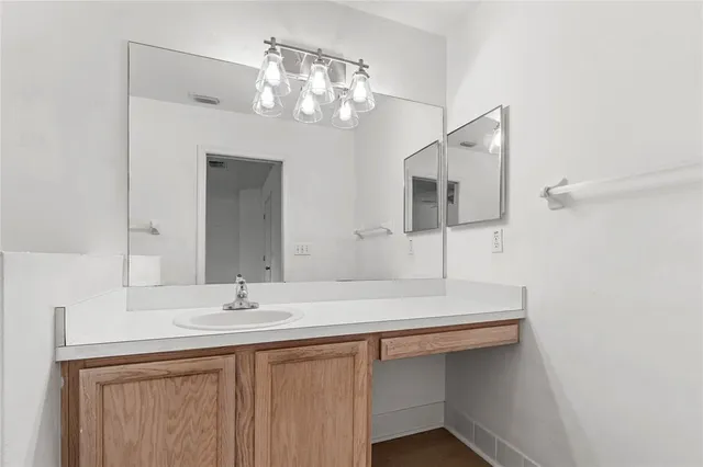 a bathroom with a sink a large mirror and vanity