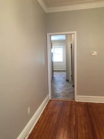 a view of a room with wooden floor and chandelier