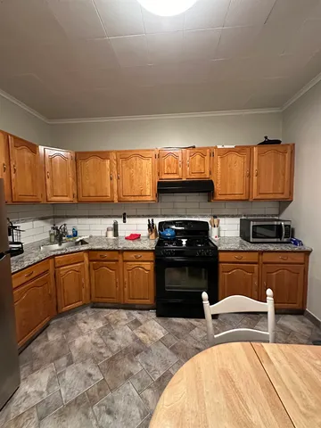 a kitchen with stainless steel appliances granite countertop a stove sink and cabinets