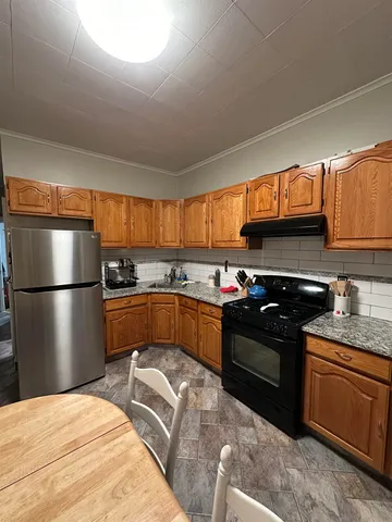 a kitchen with stainless steel appliances granite countertop a stove a sink dishwasher a refrigerator and cabinets with wooden floor