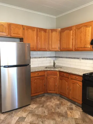 a kitchen with stainless steel appliances granite countertop a refrigerator sink and cabinets