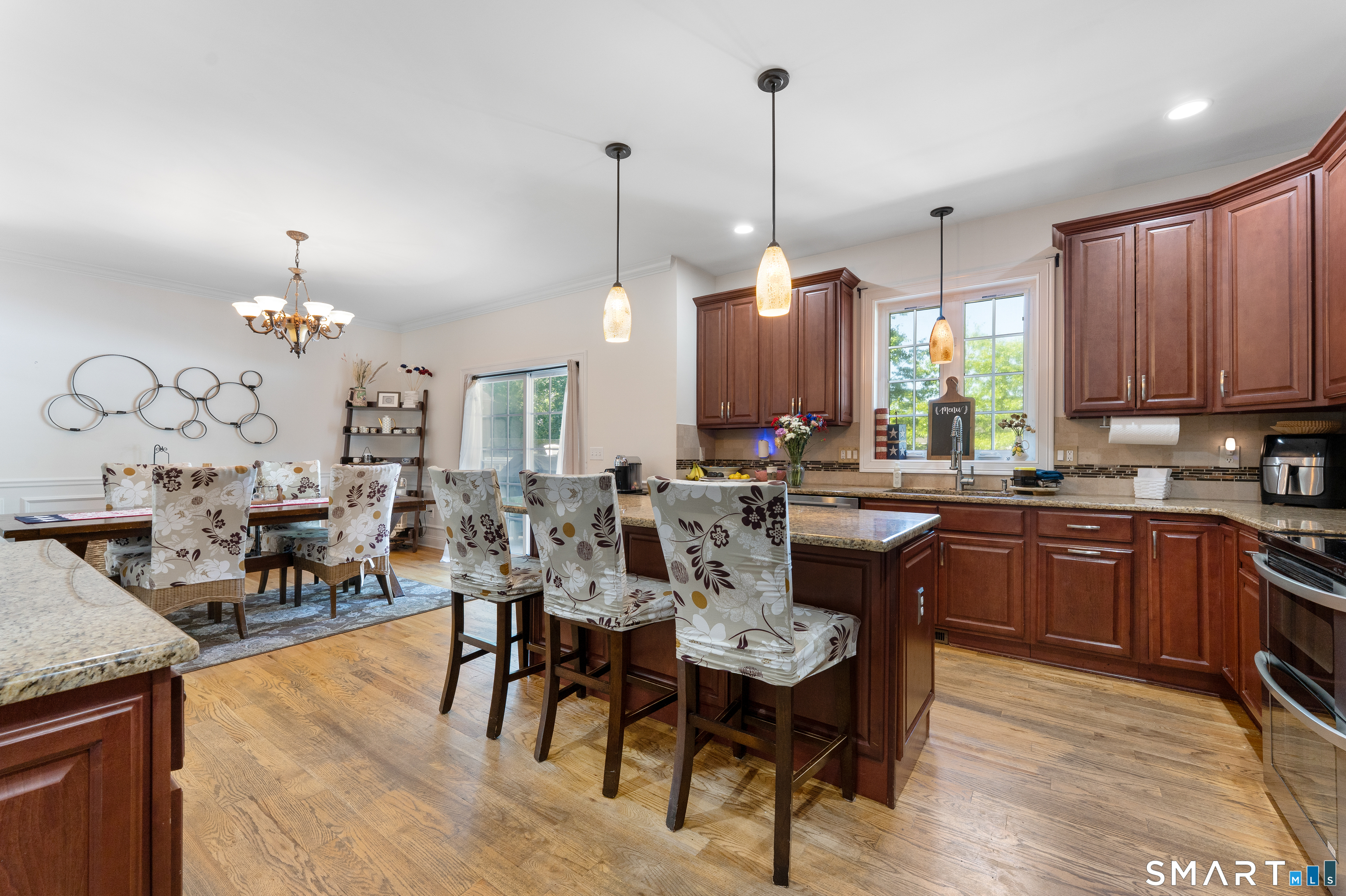 261 Spring Road North Haven, CT 06473 - Photo 17 of 39 a open kitchen with stainless steel appliances kitchen island granite countertop a table chairs and a chandelier