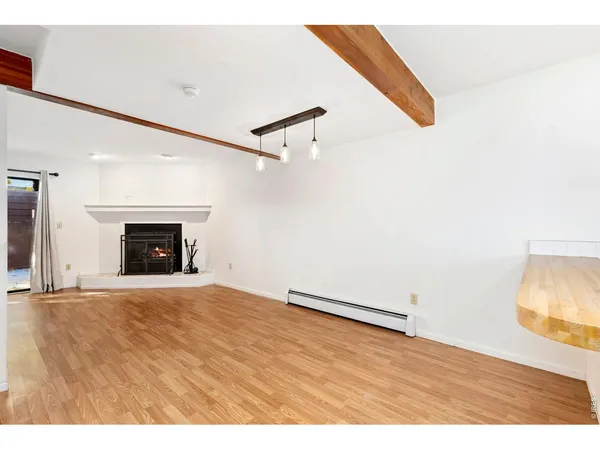 a view of an empty room with a fireplace and a window