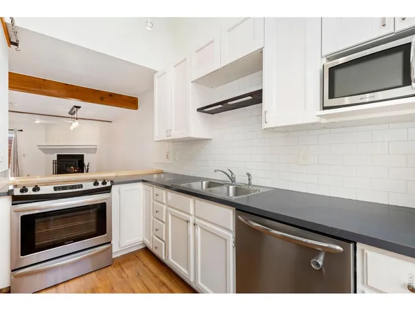 a kitchen with stainless steel appliances a stove a sink and a microwave