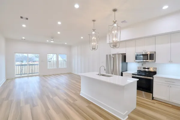 a large kitchen with kitchen island a large island in the center and stainless steel appliances