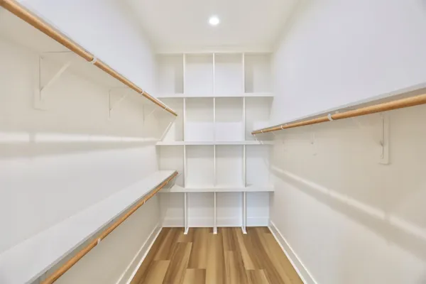 a view of walk in closet with empty racks