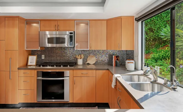 a kitchen with stainless steel appliances granite countertop a sink stove and microwave