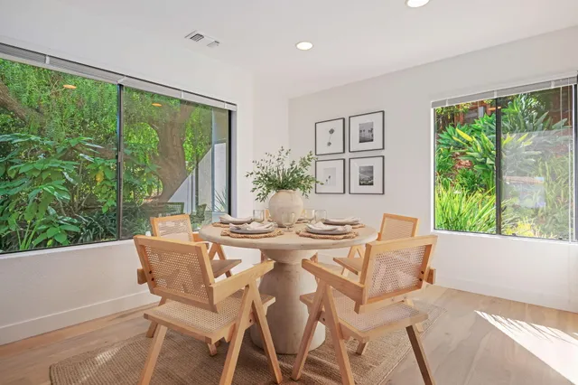 a view of a dining room with furniture large windows and wooden floor