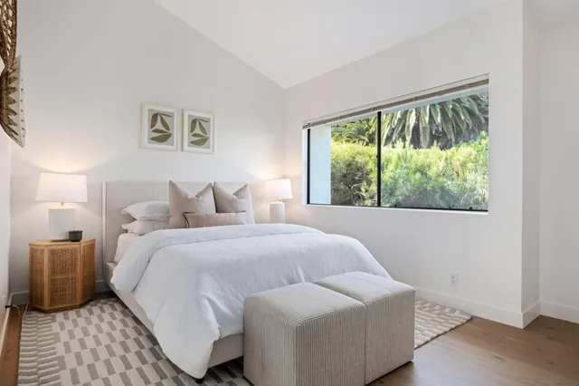 a bedroom with a bed and a large window