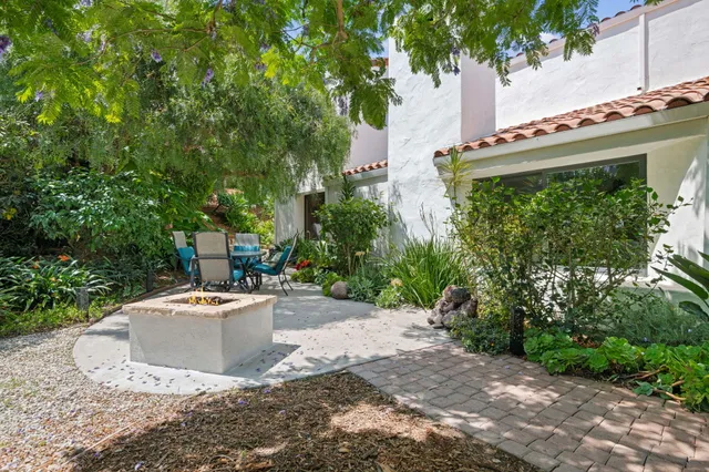 a white house that has a tree in front of it