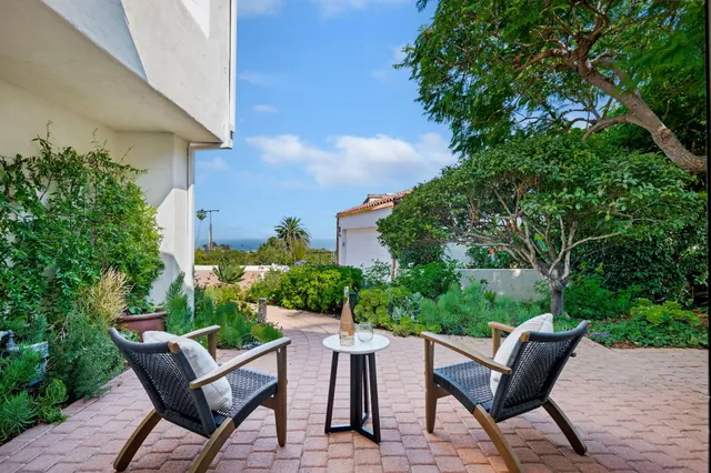 a view of a chairs and table in the backyard of a house
