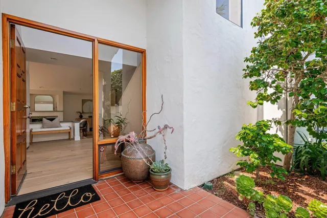 a view of a balcony with chairs and a potted plant