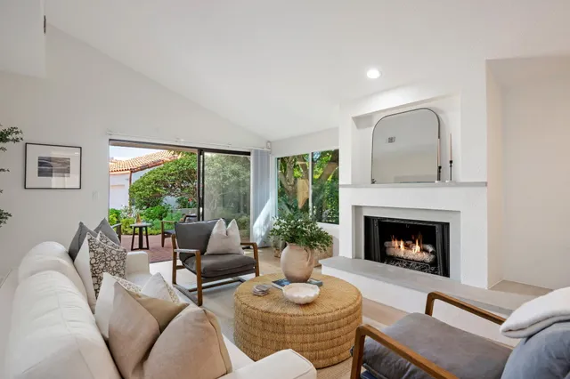 a living room with furniture fireplace and a large window