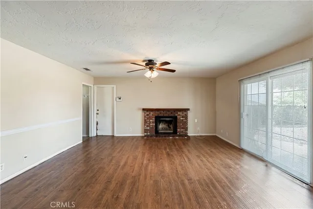 a view of an empty room with a window and fireplace